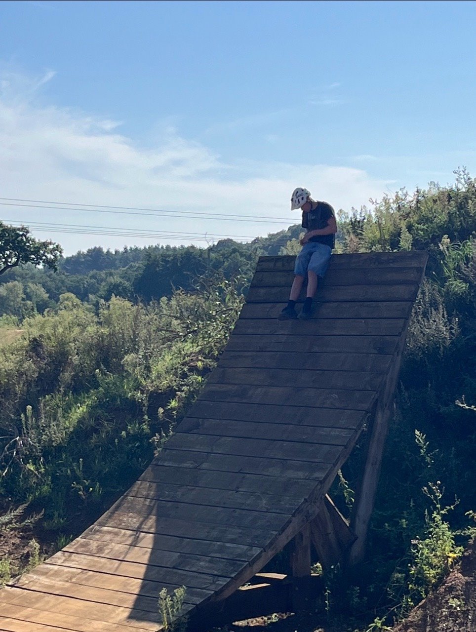 Rider sitting on a wooden feature at Twisted Oaks Bike Park
